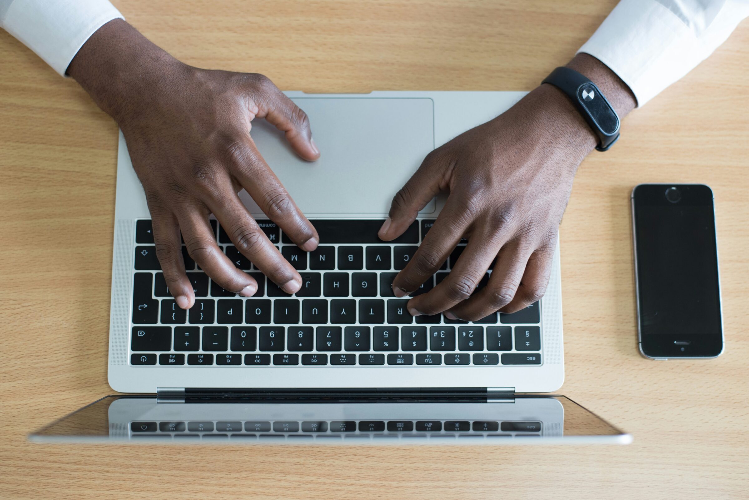 hands that are typing on a laptop keyboard